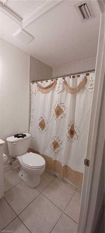 Guest Bathroom featuring tile flooring, a white toilet, and a shower with tiled walls