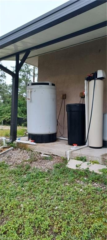 Outdoor utility area featuring a water filtration system and A/C, and covered patio extension