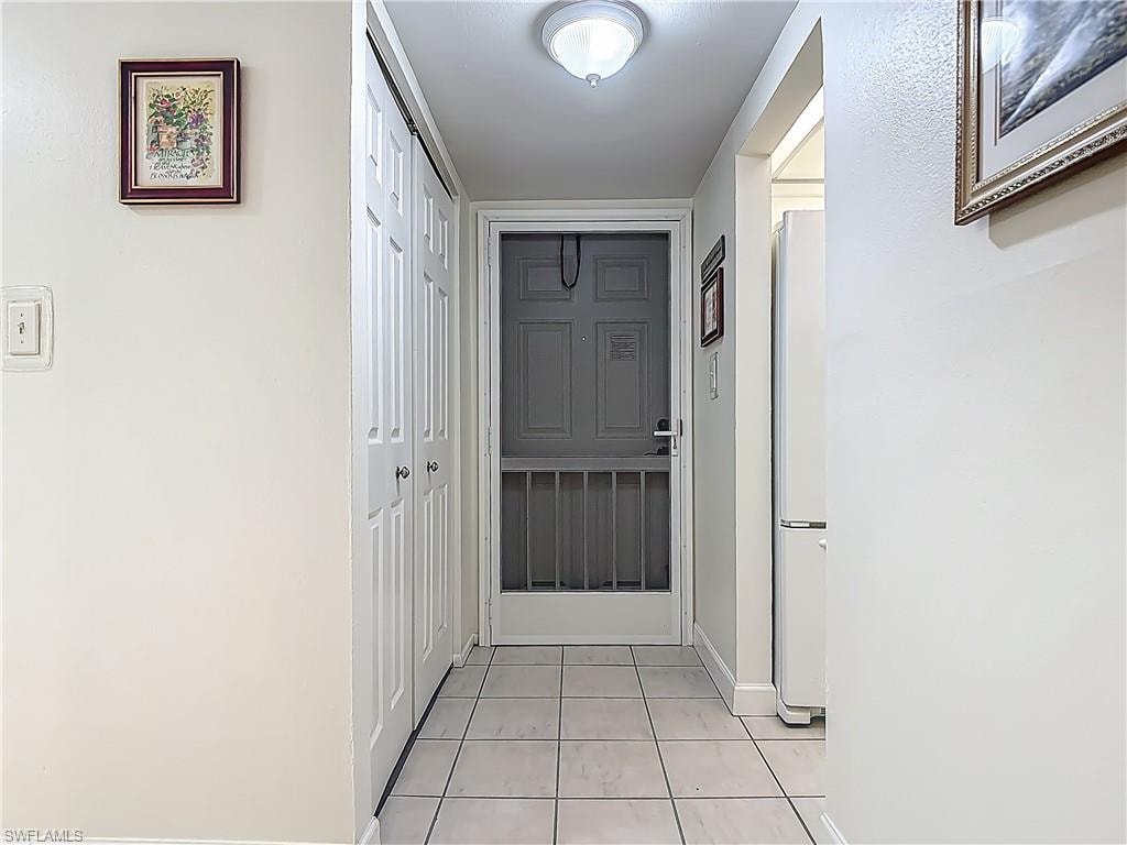 Hall featuring light tile patterned flooring and baseboards