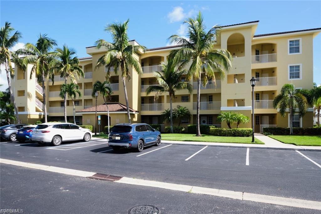 Multi-story building featuring a stucco exterior with multiple balconies and exterior staircases