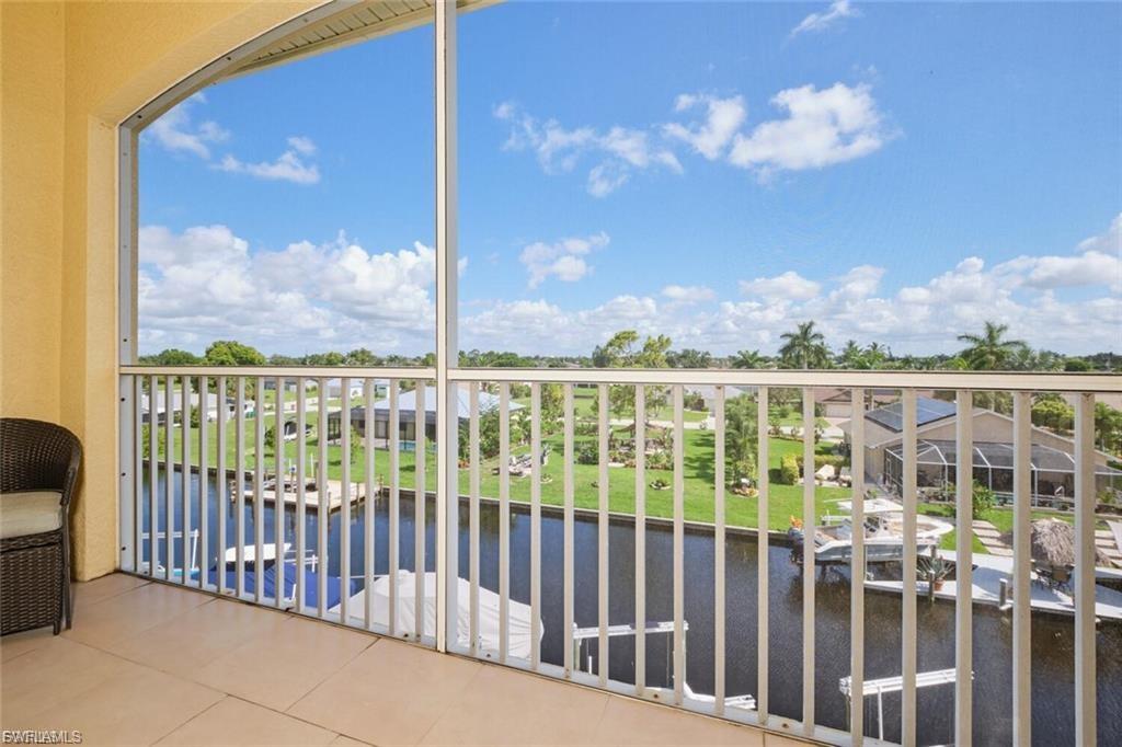 Screened balcony featuring tiled flooring and a serene canal backdrop