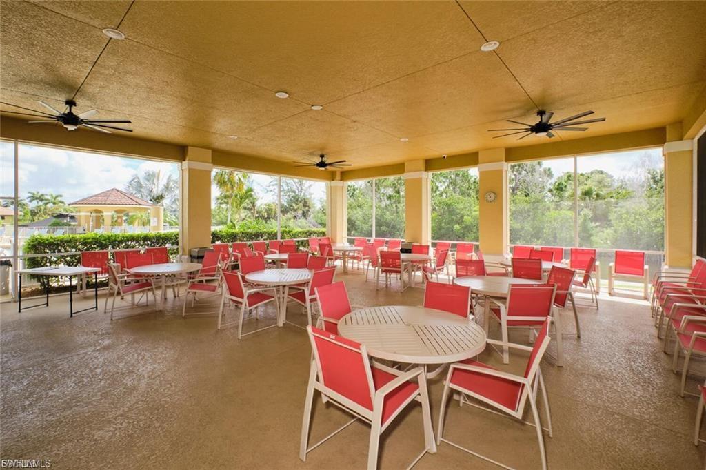 Expansive covered patio with textured flooring, multiple ceiling fans, and an open-air design