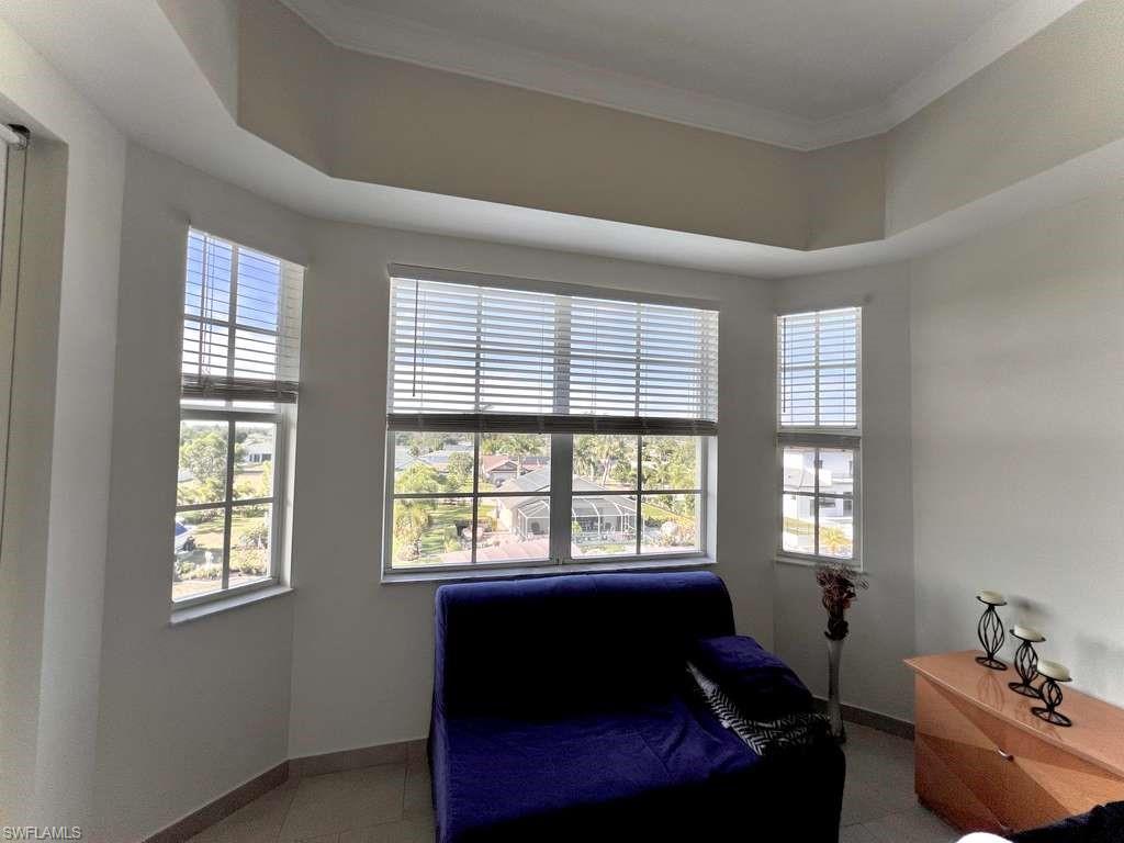 Bay window feature with multiple windows, crown molding detail, and tile flooring