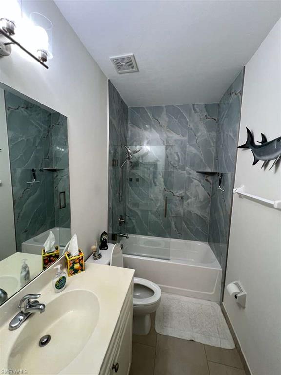 Bathroom featuring a full tub with a glass shower enclosure and a shower system with a handheld showerhead