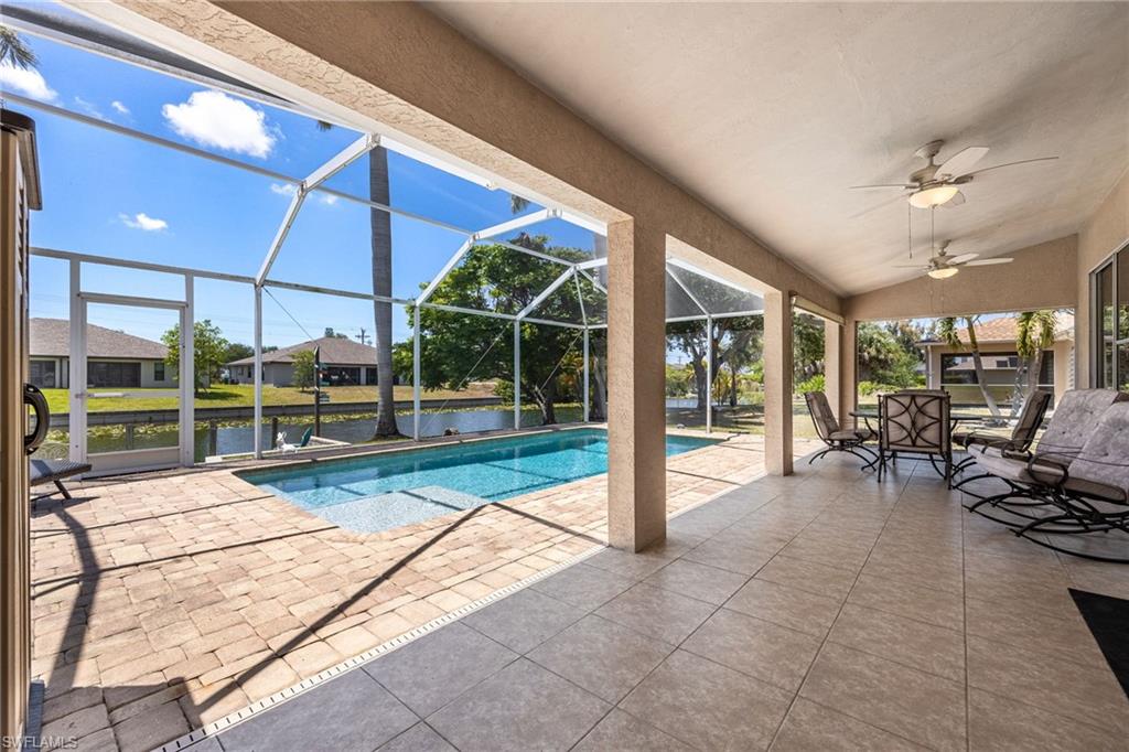 Screened lanai featuring a swimming pool, canal frontage, and covered patio with ceiling fans