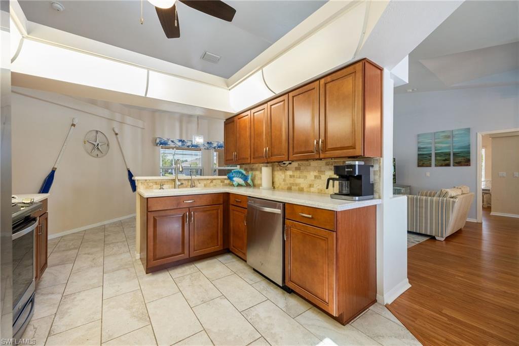 Kitchen featuring wood cabinetry, stone-finish countertops, and a tiled backsplash