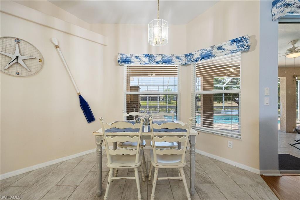Dining area with wood-finish tile flooring and windows featuring horizontal blinds