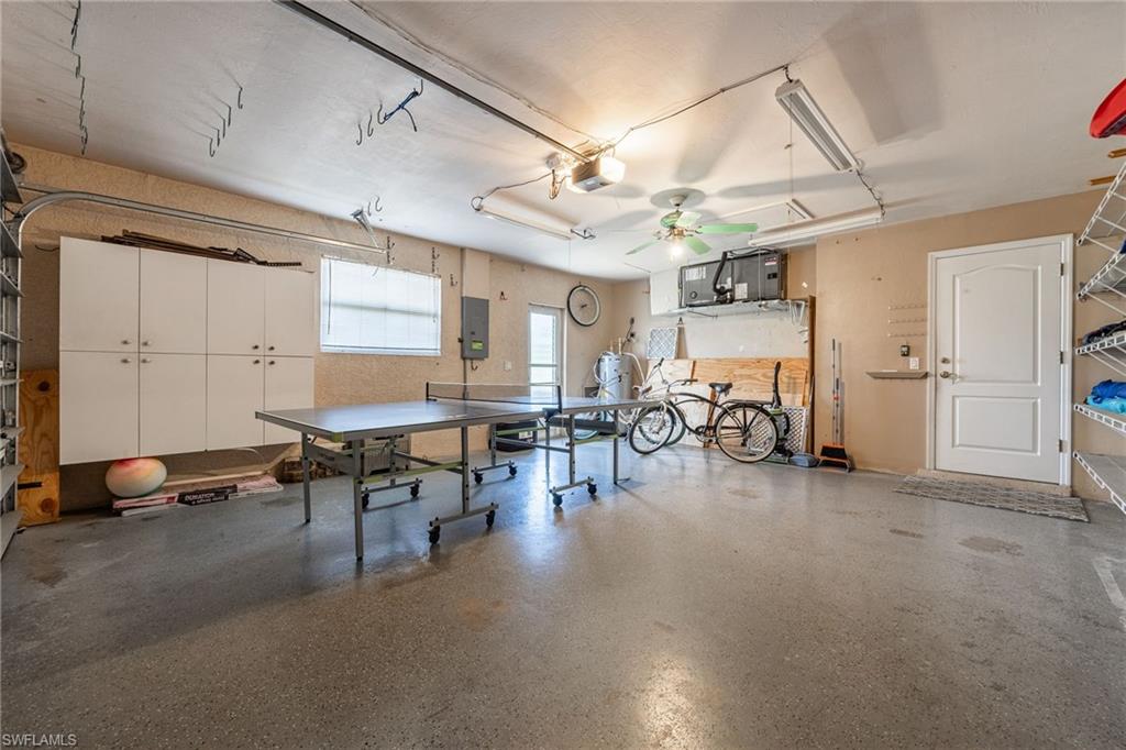 Spacious utility garage featuring concrete flooring, track lighting, and a ceiling fan