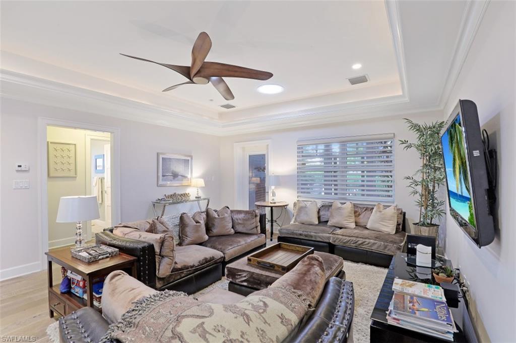 Living area featuring a tray ceiling, ceiling fan, light wood-style flooring, recessed lighting, and ornamental molding