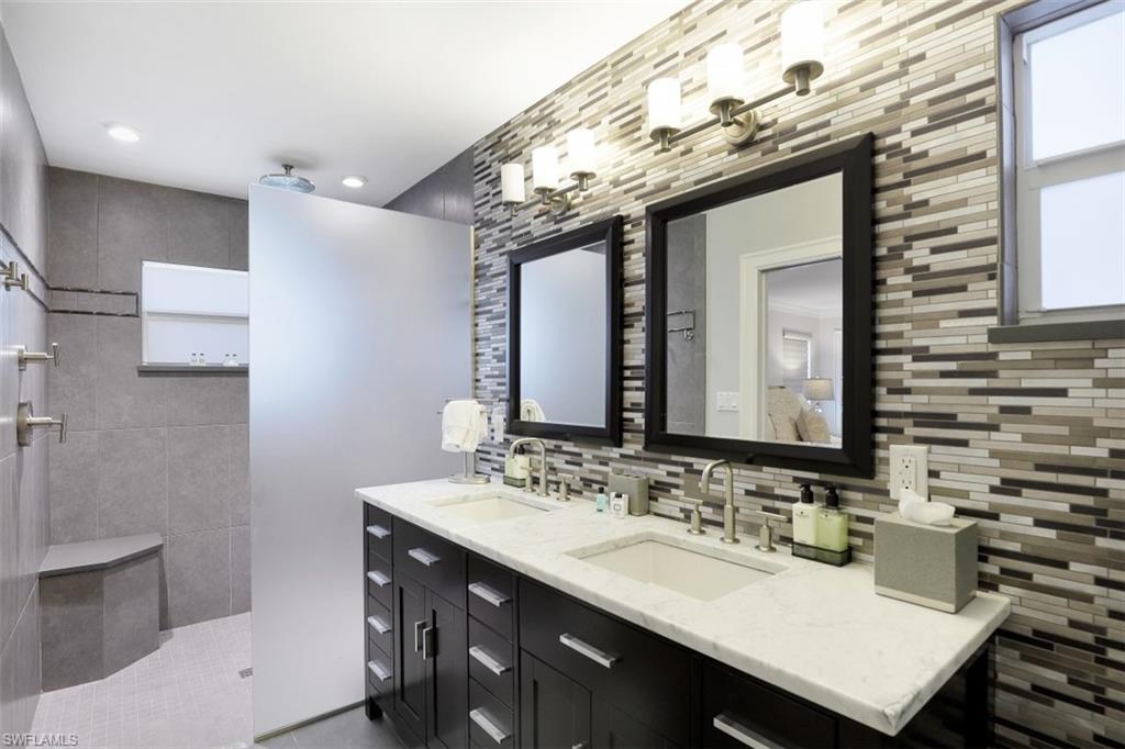 Full bath featuring tasteful backsplash, walk in shower, double vanity, and recessed lighting