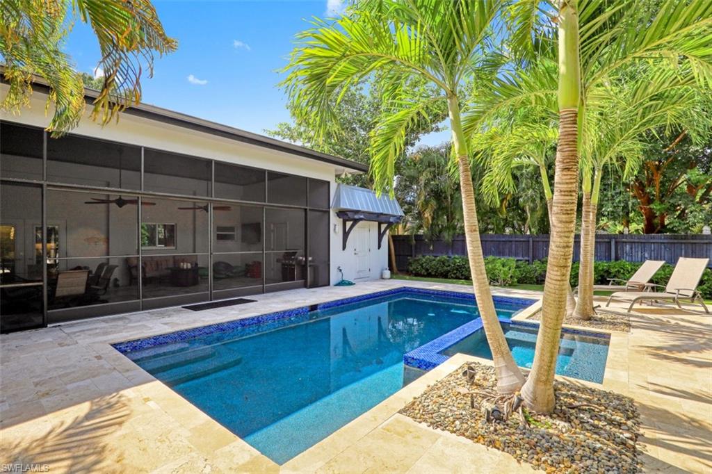 View of pool featuring ceiling fan, a fenced backyard, a patio, and a pool with connected hot tub