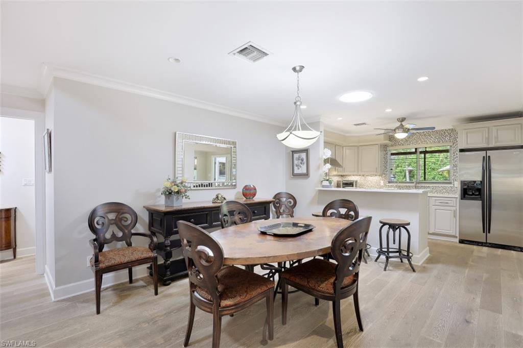 Dining room featuring light wood-style flooring, crown molding, a ceiling fan, recessed lighting, and baseboards