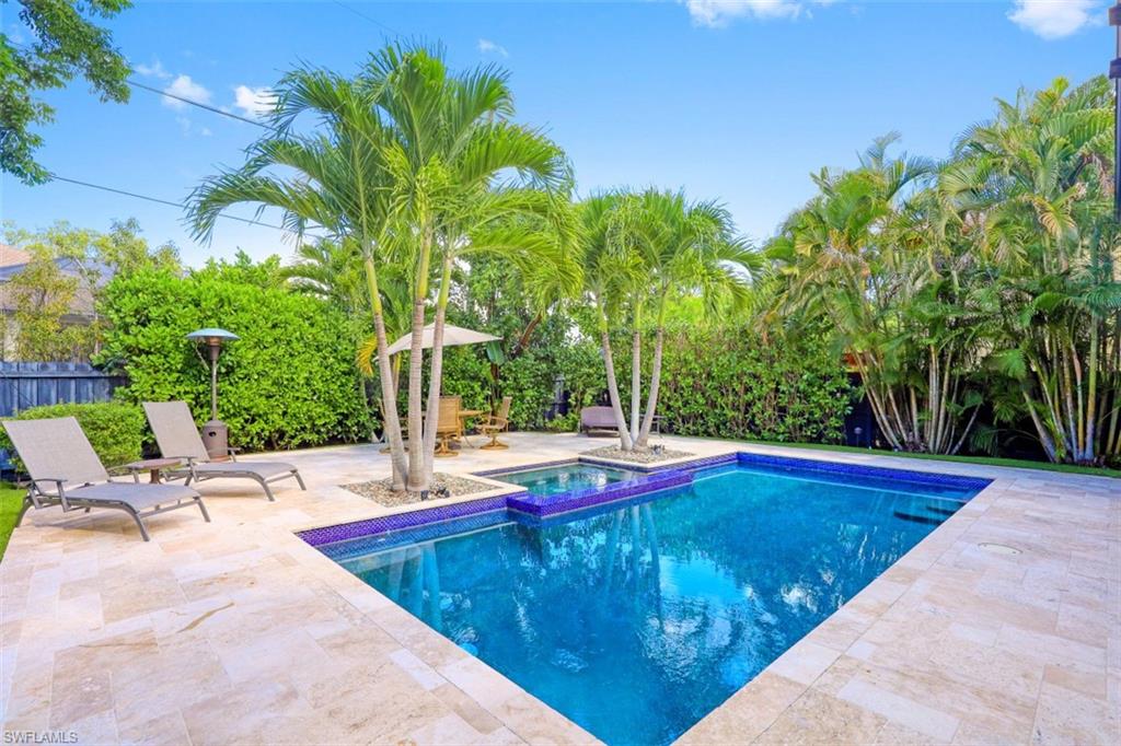 View of swimming pool with a patio area, fence, and a pool with connected hot tub