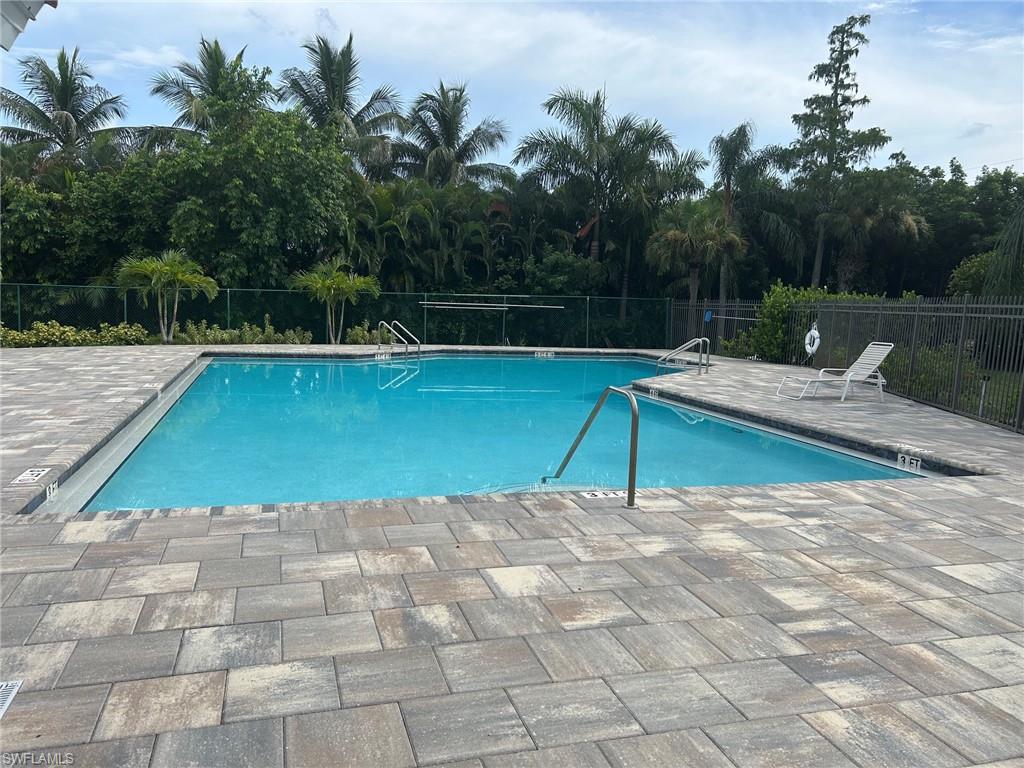 Rectangular swimming pool featuring a light blue finish, surrounded by multi-toned paver decking