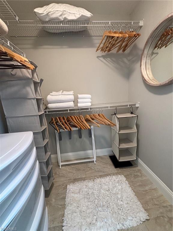 Spacious closet featuring wire shelving, light gray wall paint, and tile flooring