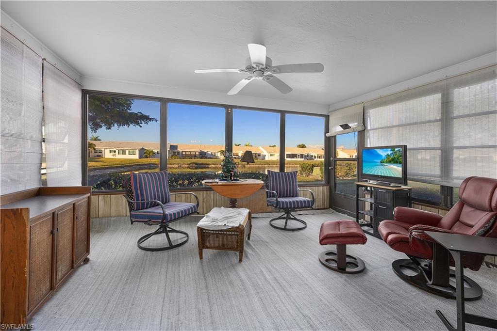 Sunroom featuring a residential view and carpet