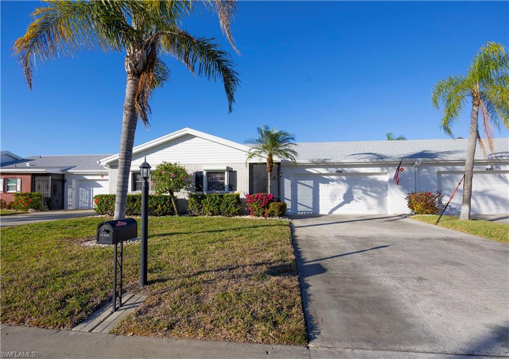 Single story home with concrete driveway, a front lawn, and an attached garage