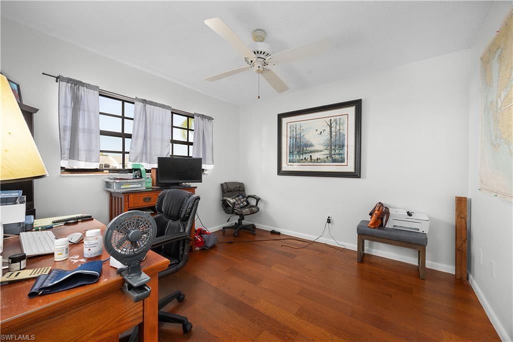 Office with dark wood finished floors and ceiling fan
