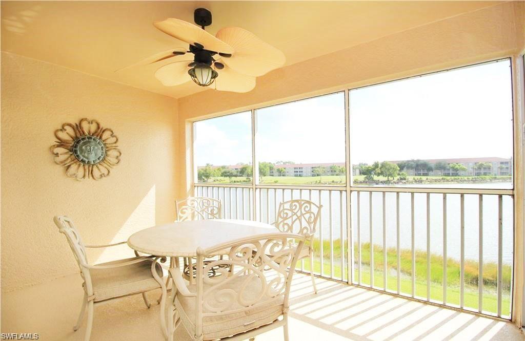 Sunroom with ceiling fan and a water view