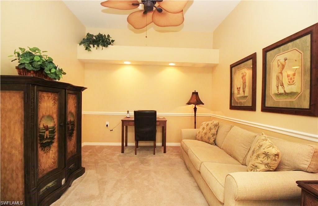 Living area with ceiling fan and light carpet