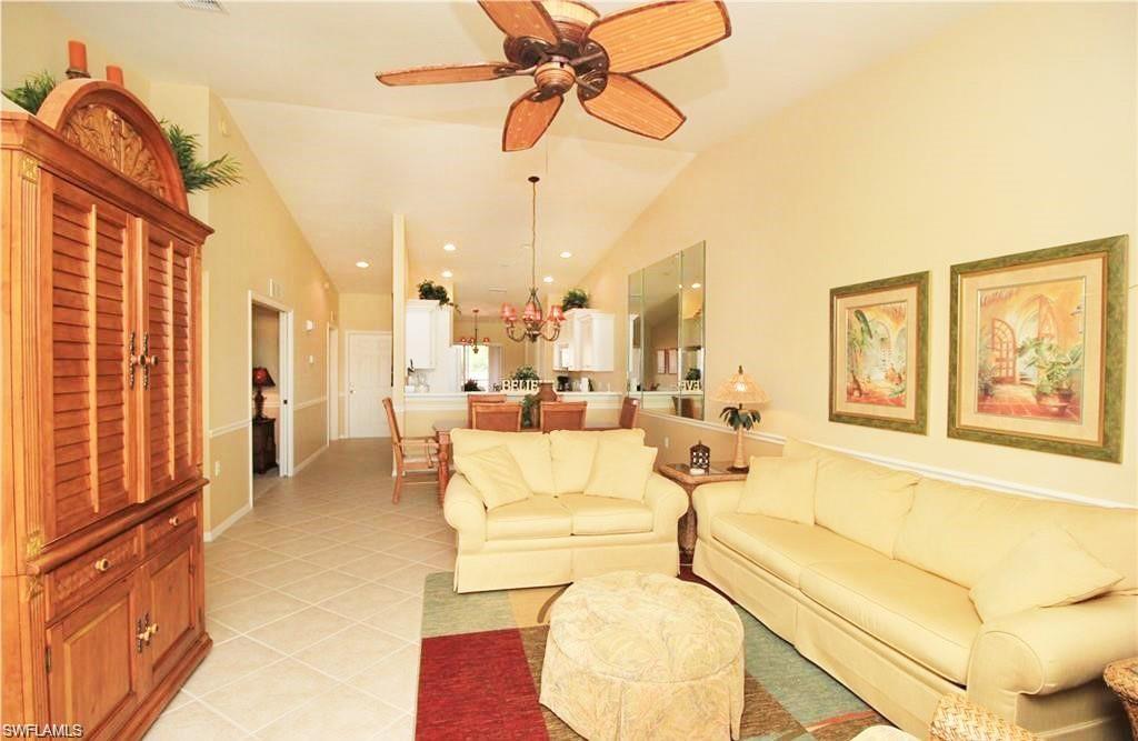 Living room featuring ceiling fan, light tile patterned floors, and high vaulted ceiling