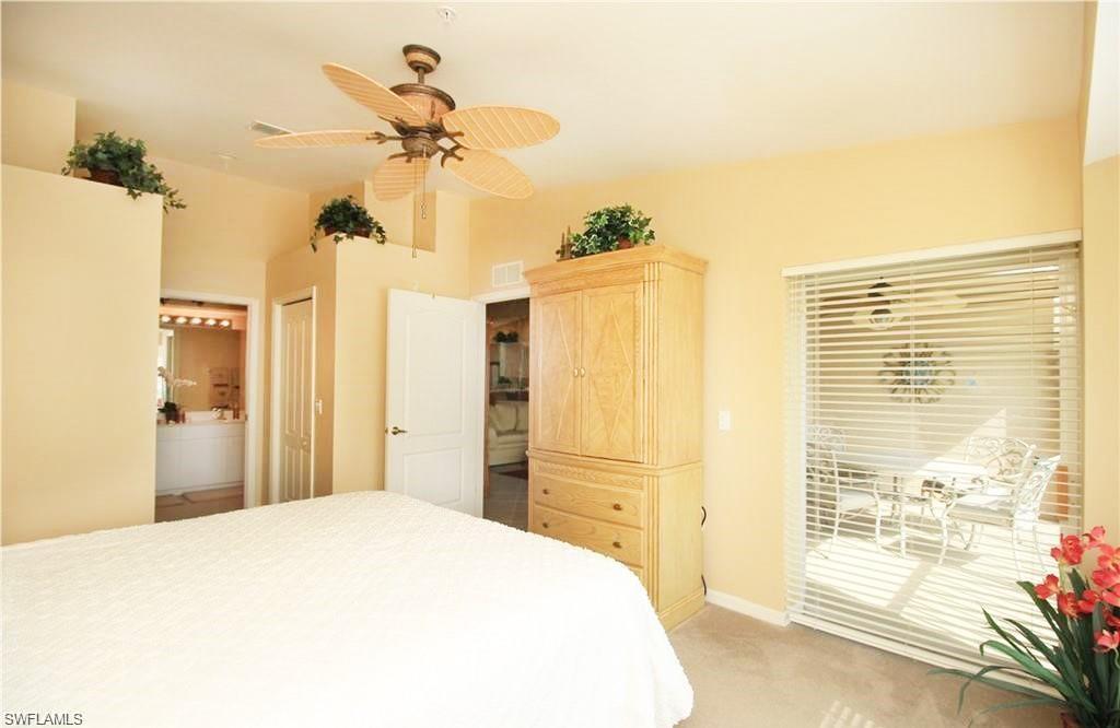 Carpeted bedroom with connected bathroom, access to exterior, ceiling fan, and a closet