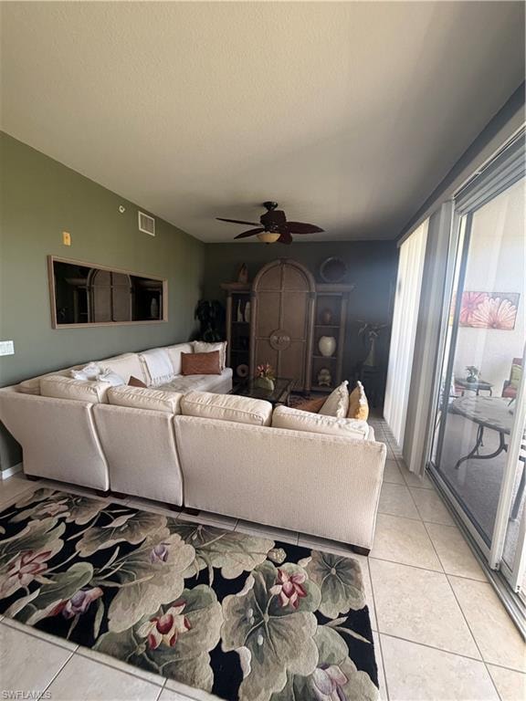 Spacious living area featuring tile flooring, a ceiling fan, and direct access to an outdoor patio through sliding glass doors