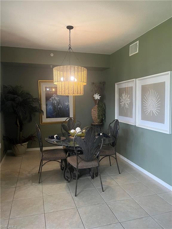 Dining area with neutral tile flooring and green-painted walls