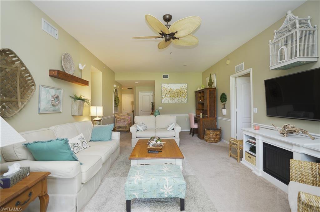 Carpeted living room with ceiling fan