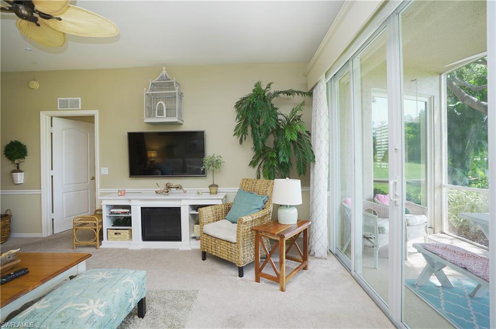 Living area with light carpet and ceiling fan