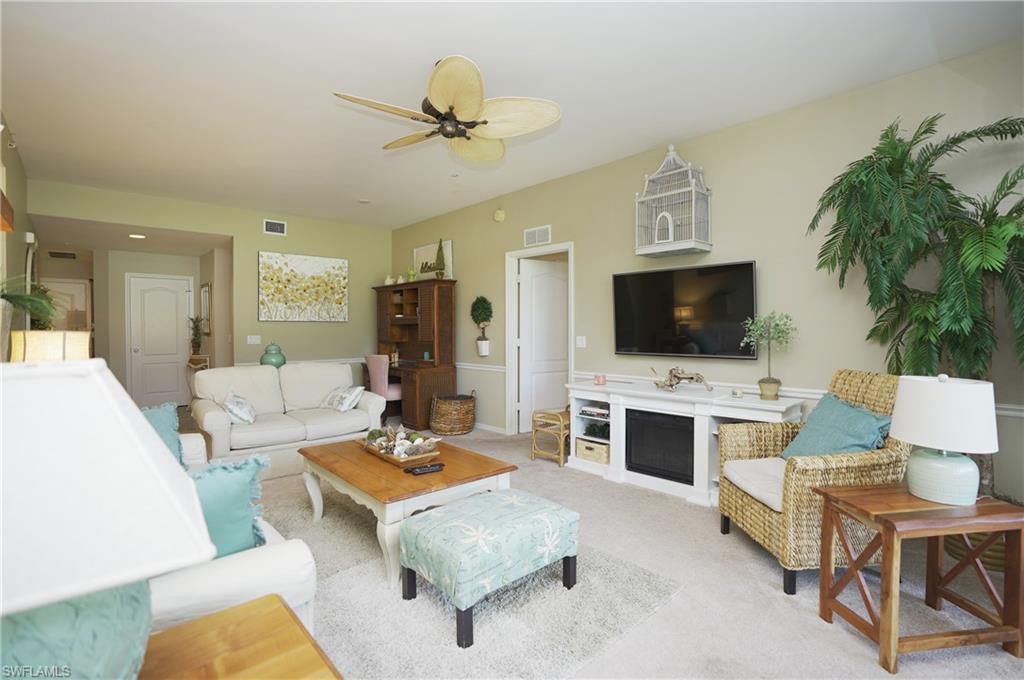 Carpeted living room with ceiling fan
