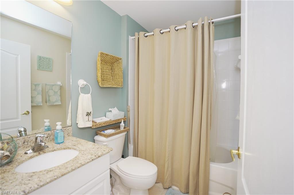 Full bathroom with shower / tub combo with curtain, vanity, and toilet