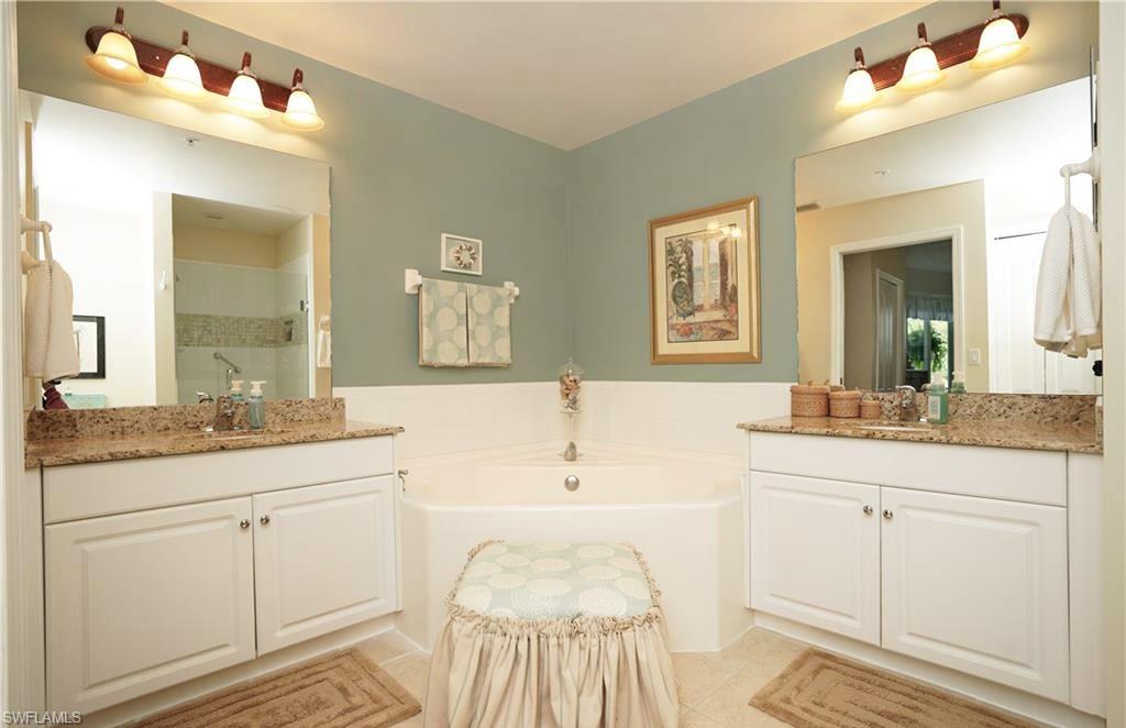 Bathroom featuring vanity, tile patterned flooring, and separate shower and tub