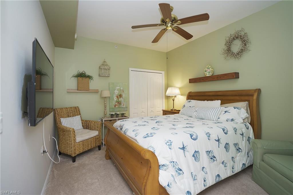 Carpeted bedroom with a closet and ceiling fan