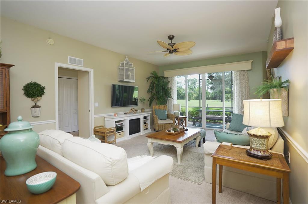 Carpeted living room featuring ceiling fan