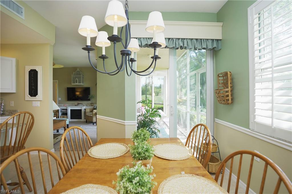 Dining space featuring carpet floors, an inviting chandelier, and a wealth of natural light
