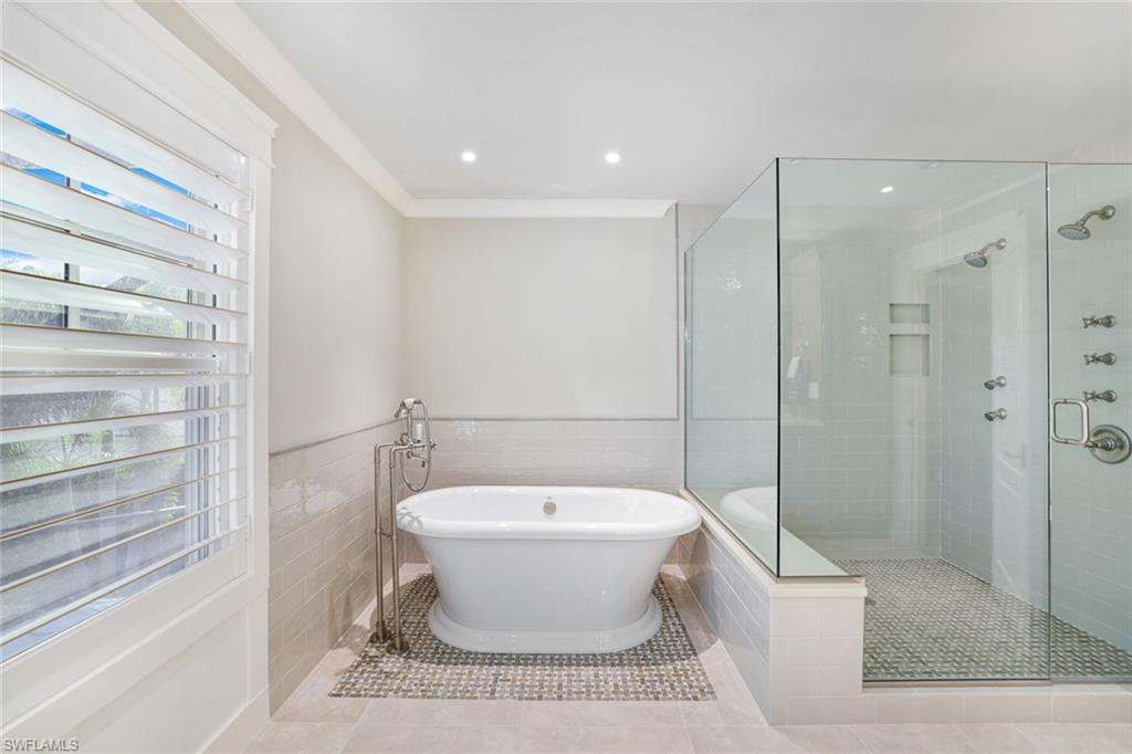 Bathroom with tile patterned flooring, plus walk in shower, and tile walls