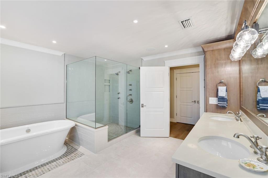 Bathroom featuring tile patterned flooring, vanity, separate shower and tub, and ornamental molding