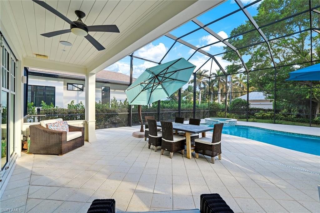 View of patio / terrace with a swimming pool with hot tub, a lanai, and ceiling fan