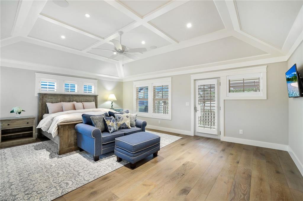 Bedroom with ceiling fan, coffered ceiling, wood-type flooring, and access to outside