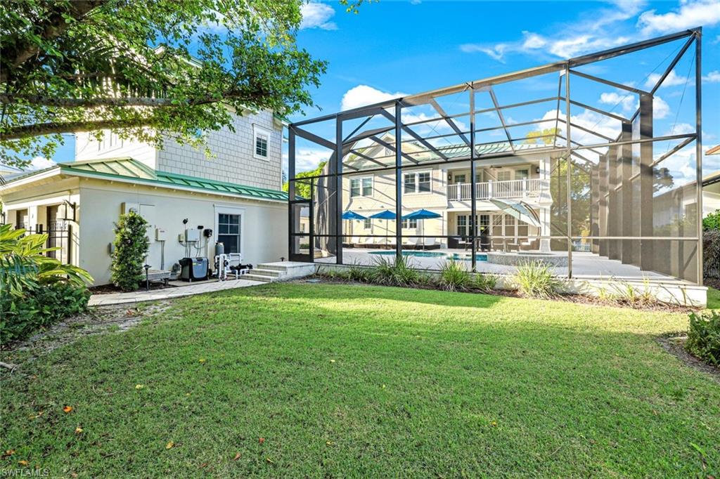 Rear view of property with a patio, a lawn, and a lanai