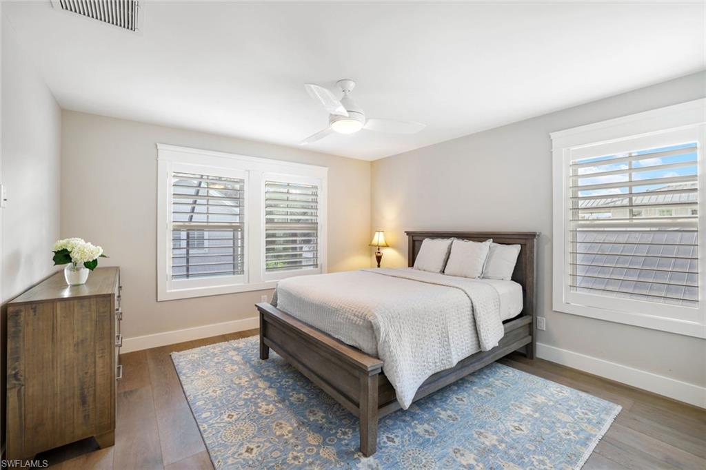 Bedroom featuring wood-type flooring, multiple windows, and ceiling fan