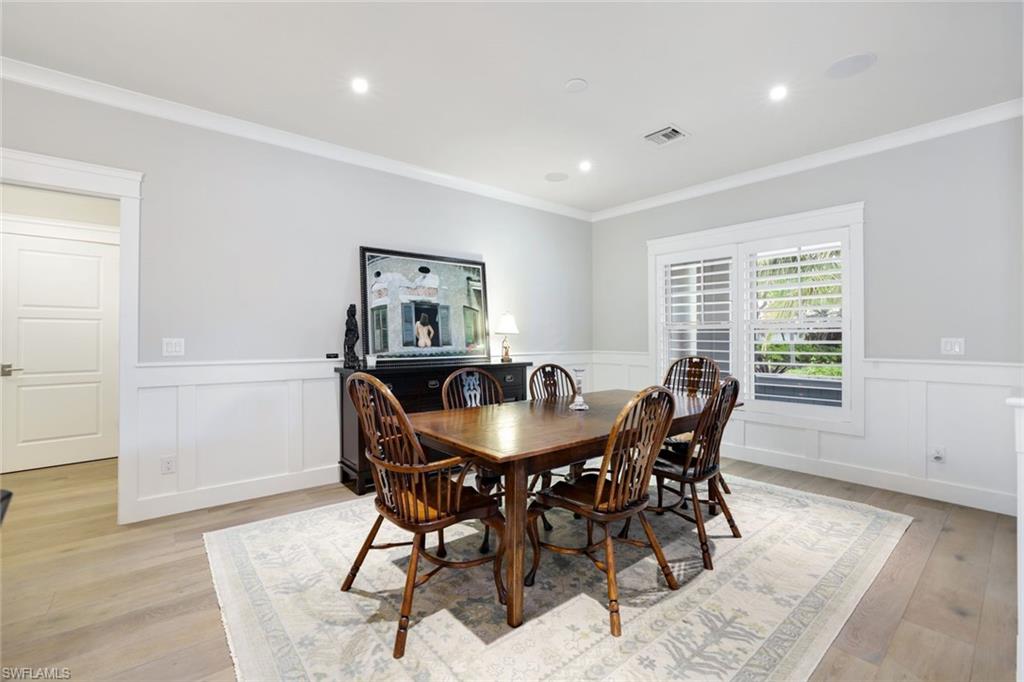 Dining area with light hardwood / wood-style floors and ornamental molding