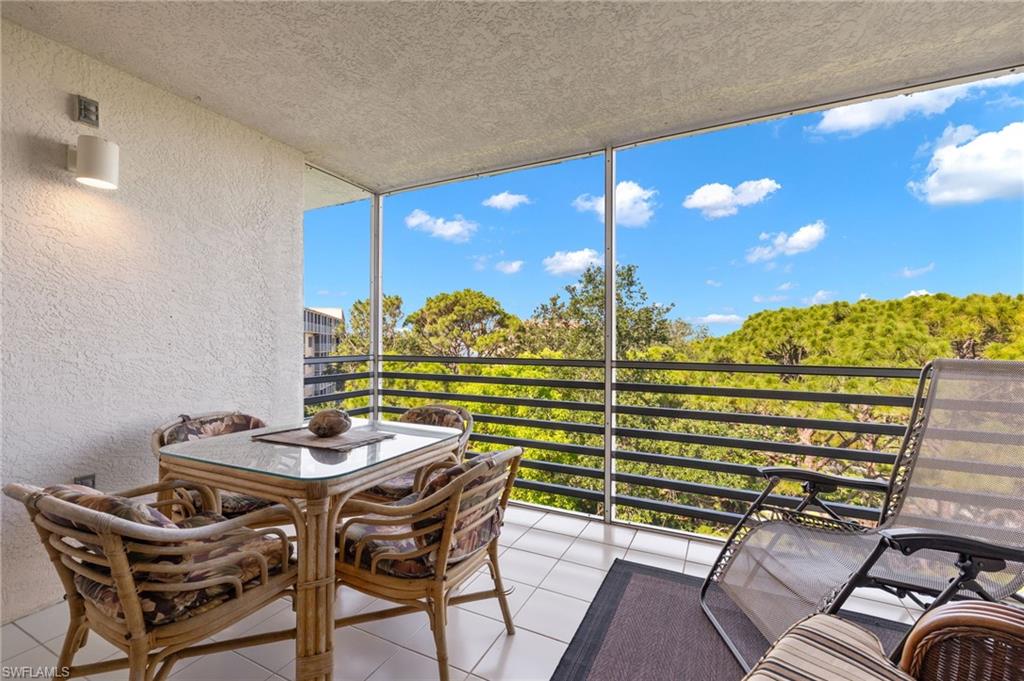 Screened balcony featuring white tile flooring and textured walls