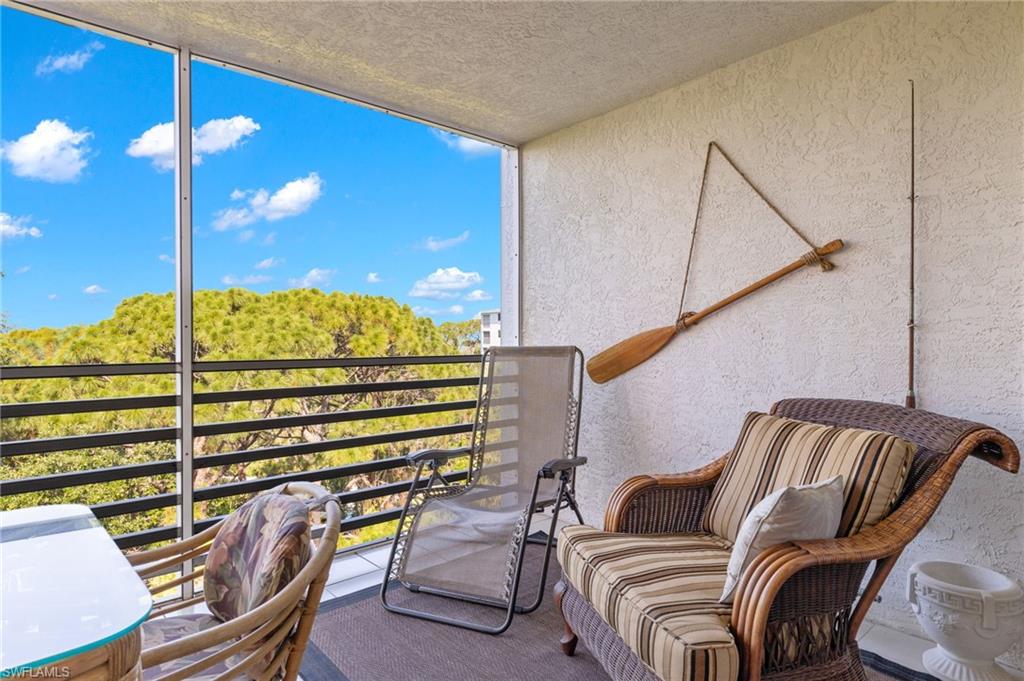 Screened balcony featuring textured wall finish and dark metal railings