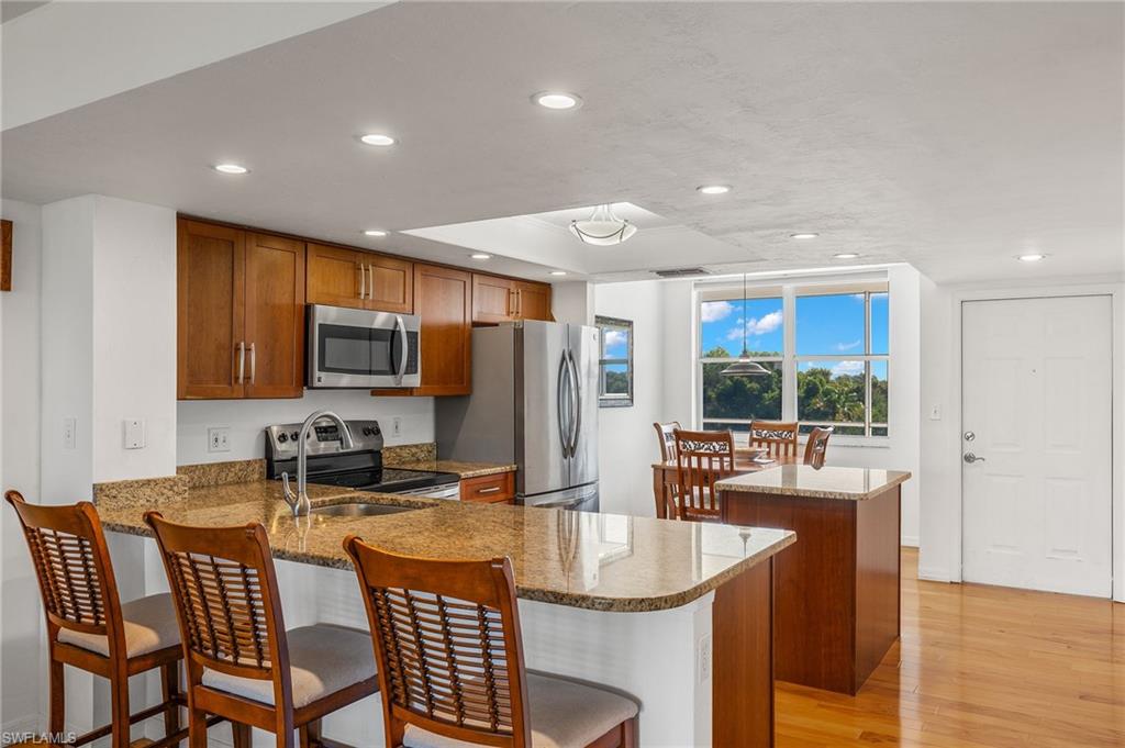 Kitchen featuring granite countertops, wood cabinetry, and stainless steel appliances