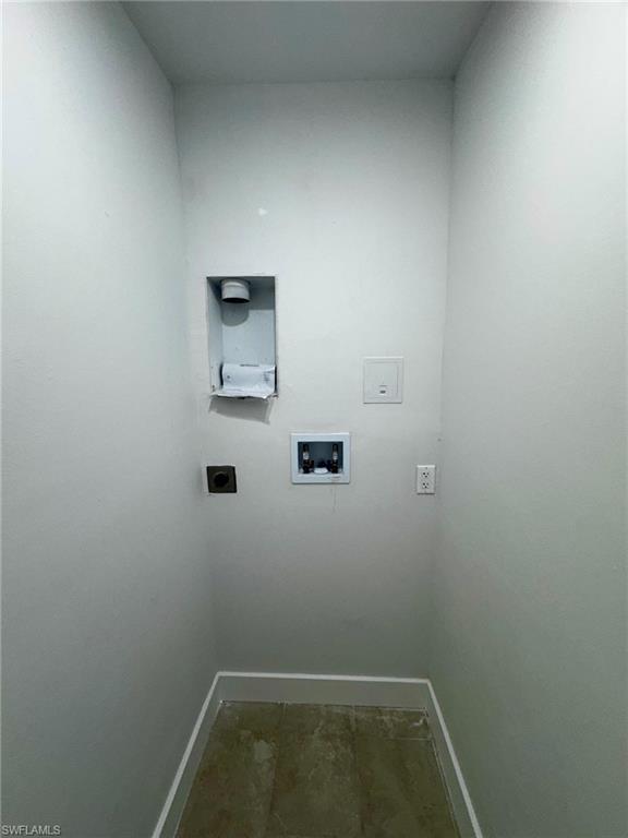 Dedicated laundry area with tile flooring and light gray walls