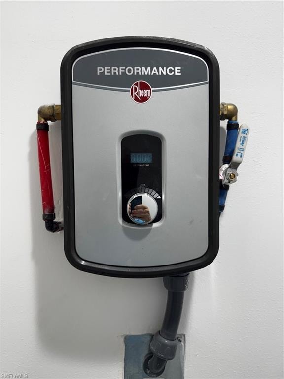 Wall-mounted Rheem Performance water heater unit featuring a digital display, control dial, and visible plumbing connections