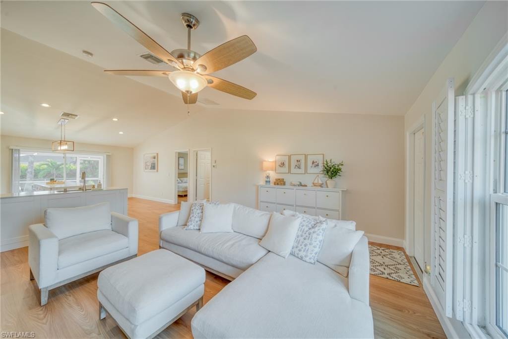 Living room with light wood finished floors, recessed lighting, and ceiling fan
