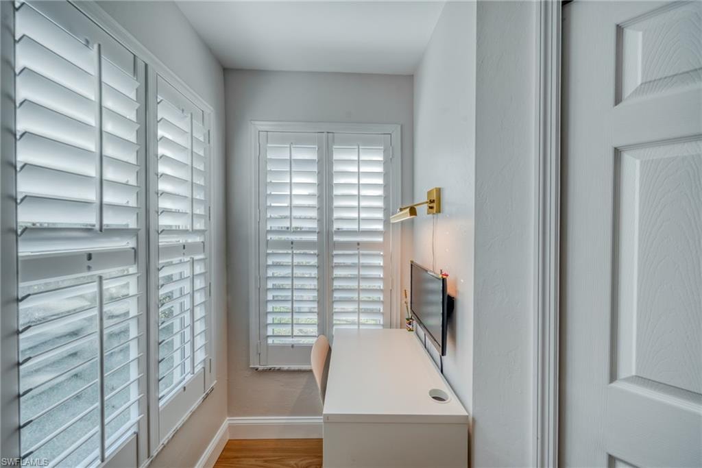 Office area with light wood-style floors and plenty of natural light